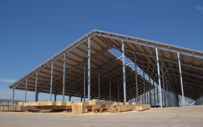 Matériaux bois stockés sous un hangar agricole - Source : Mon Hangar