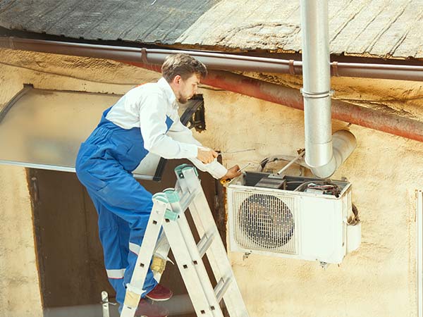 Un homme répare une pompe à chaleur pour son entretien